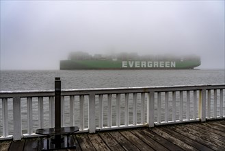 Thick fog in winter, hanging over the mouth of the Elbe into the North Sea, container ship Ever