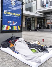 Homeless man sleeping in front of the entrance to Dortmund Central Station, North Rhine-Westphalia,