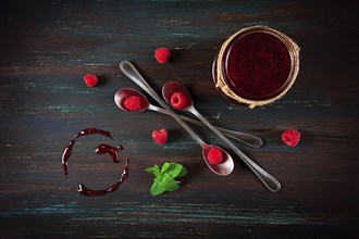 Raspberry jam, on a dark wooden background, top view, selective focus, food concept, no people