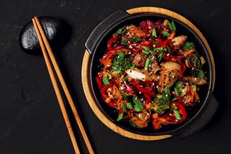 Asian cuisine, teriyaki meat with vegetables, in a cast-iron frying pan, close-up, no people