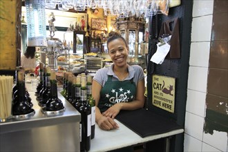 Smiling barmaid inside famous historic Los Gatos Cervecerias bar, Madrid city centre, Spain, Europe