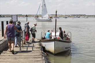 Passengers boarding River Deben foot passenger ferry boat at Bawdsey Quay, Suffolk, England, UK