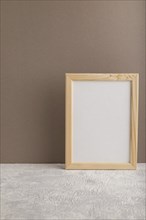 White wooden frame mockup on beige paper background. Blank, vertical orientation, still life, copy