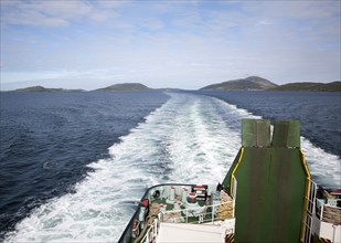 Ship's wake in sea of Caledonian MacBrayne ferry ship leaving Barra, Outer Hebrides, Scotland, UK