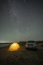 Off-road vehicle and tent, night shot, Milky Way at Lake Issyk Kul, Kyrgyzstan, Asia