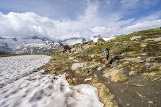 Mountaineer on hiking trail in picturesque mountain landscape, mountain peak with snow and glacier