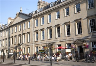 People sitting outside cafes on Georgian street of North Parade, Bath, Somerset, England, UK