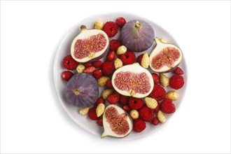 Fresh figs, strawberries and raspberries on white ceramic plate isolated on white background. top