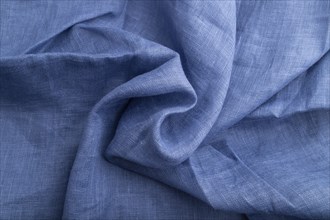 Fragment of blue linen tissue. Top view, natural textile background and texture. wave concept,