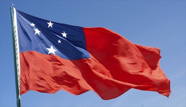 The flag of Samoa, fluttering in the wind, isolated against a blue sky