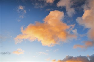 Orange spring clouds adorn the blue morning sky at sunrise