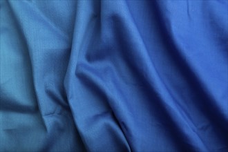 Fragment of cotton blue tissue. Top view, natural textile background and texture. wave concept,