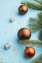 Christmas or New Year composition. Decorations, bronze balls, fir and spruce branches, on a blue