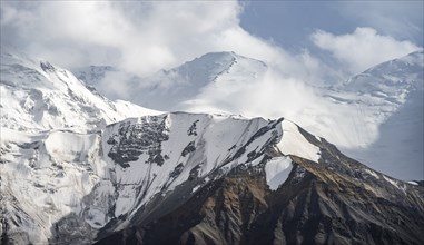 Dramatic mountain landscape, mountain valley, behind glaciated and snow-covered mountain peak Pik