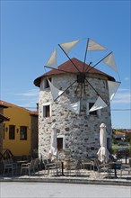 Traditional windmill converted into a café under a clear blue sky, Ierissos, Sithonia, Halkidiki,