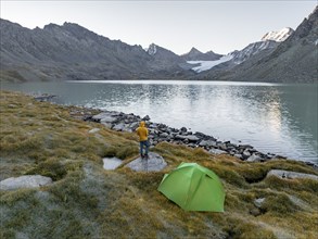 Hikers wild camping, camping with tent in the mountains with glacier, mountain pass and mountain