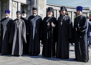 Russian Orthodox priests stand at the Soviet memorial on Straße des 17. Juni to commemorate the