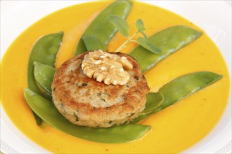 Vegetarian cuisine, walnut cakes on sugar snap peas with pumpkin sauce, sauce, vegetables, snow