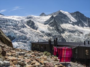 Colored bed linen dries in the sun, mountain hut Cabane de Moiry, located close to the retreating