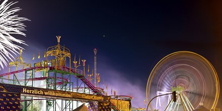 Cranger Kirmes with colourfully illuminated fairground rides and the Ferris wheel at night, Herne,