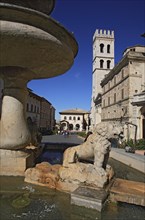 Piazza del Comune market square, fountain and church of Santa Maria sopra Minerva in Assisi,