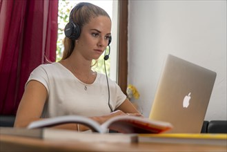 Young student learns at home, online, in conversation with other students