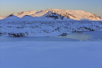 Morning light on a snowy lava field, lake, volcanic crater, snow, winter, Berserkjahraun,