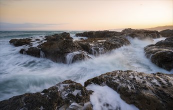 Waves washing over rocks by the sea, long exposure, coastal landscape at sunset, Playa Cocalito,