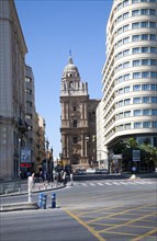 Historic cathedral framed by modern buildings, Malaga, Spain viewed up Molino Laria street