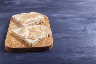 Sandwiches with pollock roe on a wooden kitchen board against black background. with copy space