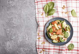 Fresh salmon with pineapple, spinach and cashew on a gray concrete background. Top view, copy