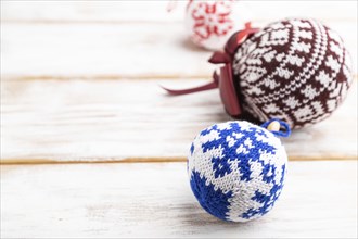 Christmas or New Year composition. Decorations, knitted balls, on a white wooden background. Side