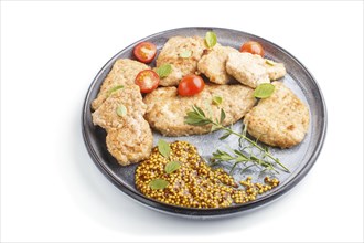 Fried pork chops with tomatoes and herbs on a gray ceramic plate isolated on white background. side