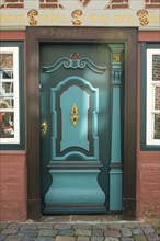 Old green door made of wood in a half-timbered building from the 17th century, carvings and