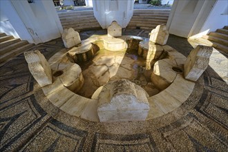 Circular stone fountain with several seats and a stone floor, thermal springs, thermal baths,