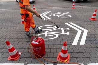 Application of road markings for a cycle lane, Rüttenscheider Straße in Essen, in the shopping and