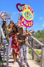 Colourfully dressed youths with musical instruments and banners form a love parade and promote the