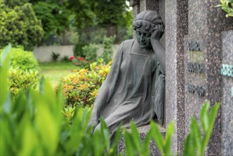 Figure in a cemetery, family grave, old gravestone, with flower and grave light, North