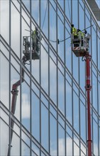 Window cleaner, building maintenance, facade cleaning, on a cherry picker, in Düsseldorf, North