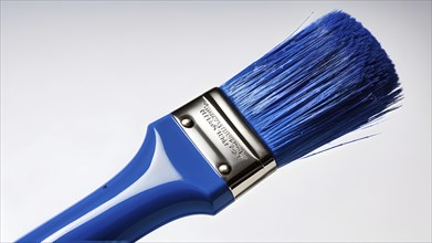 Thick paintbrush dipped in blue bristles dripping onto a white background, AI generated