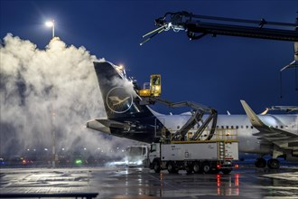 Winter at Frankfurt Main Airport, FRA, Lufthansa aircraft being de-iced by de-icing vehicles,