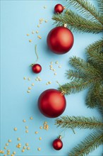 Christmas or New Year composition. Decorations, red balls, fir and spruce branches, on a blue paper