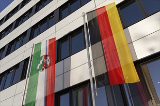 Flag with the coat of arms of the federal state of North Rhine-Westphalia and the German flag in