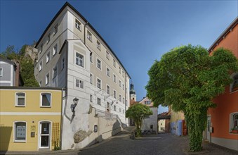 Building and cobbled path of Vils Gasse with lush tree providing shade, Kallmünz, Upper Palatinate,