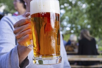 Woman (50-55) with a glass of beer in a beer garden, Prague, Bohemia, Czech Republic, Europe