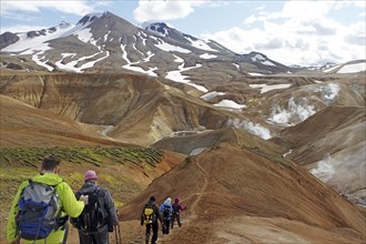 Hikers travelling in a desert-like, geothermally active mountain region, fire and ice,