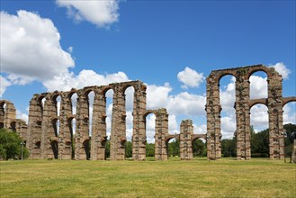 Restaurierte Bögen eines antiken Aquädukts in einer weitläufigen, offenen Landschaft, Acueducto de