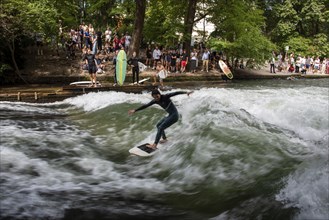 Surfers in the Eisbach, numerous onlookers on the banks, Eisbach wave in the English Garden is