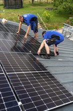 Installation of solar modules on the roof of a barn on a farm, over 240 photovoltaic modules are