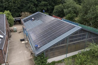 Installation of solar modules on the roof of a barn on a farm, over 210 photovoltaic modules are